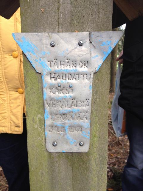 Hautapaikka Табличка на могиле изготовлена из остатков упавшего самолета
